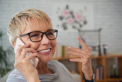 Smiling senior woman in glasses talking on phone