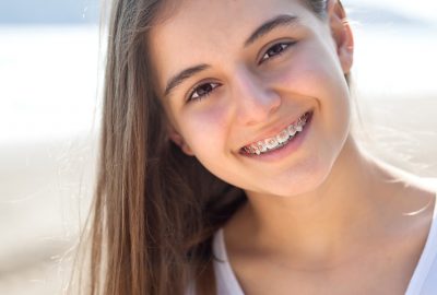 Beautiful teenage girl smiling with braces outdoors