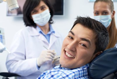Smiling young man sitting in dentist's chair